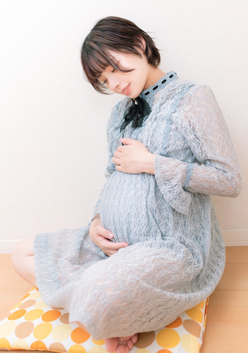 「臨月のおなかを触る妊婦」の写真［モデル：高尾実生］