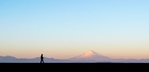 富士山をバックに散歩する男性のシルエットの写真