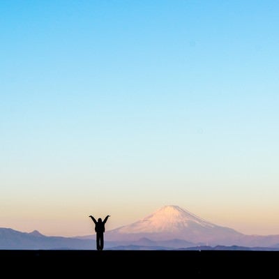 新年！富士山をバックに両手をあげる女性のシルエットの写真