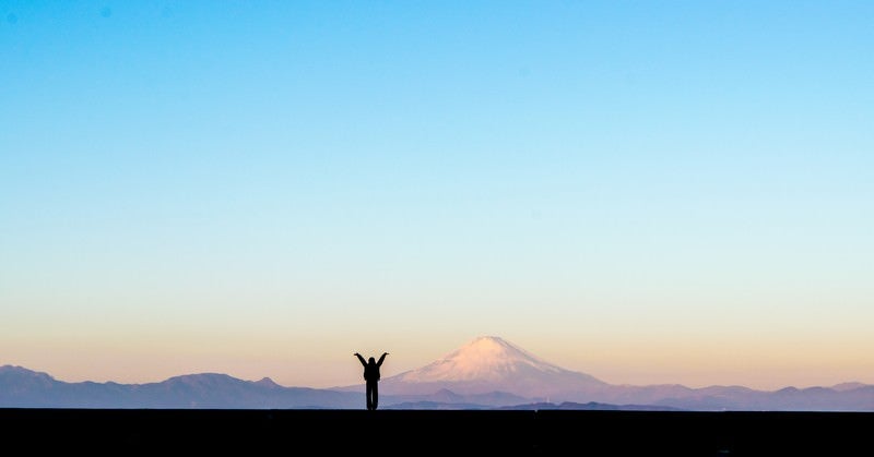 新年！富士山をバックに両手をあげる女性のシルエットの写真