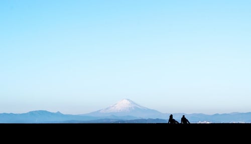 富士山を見るカップルのシルエットの写真