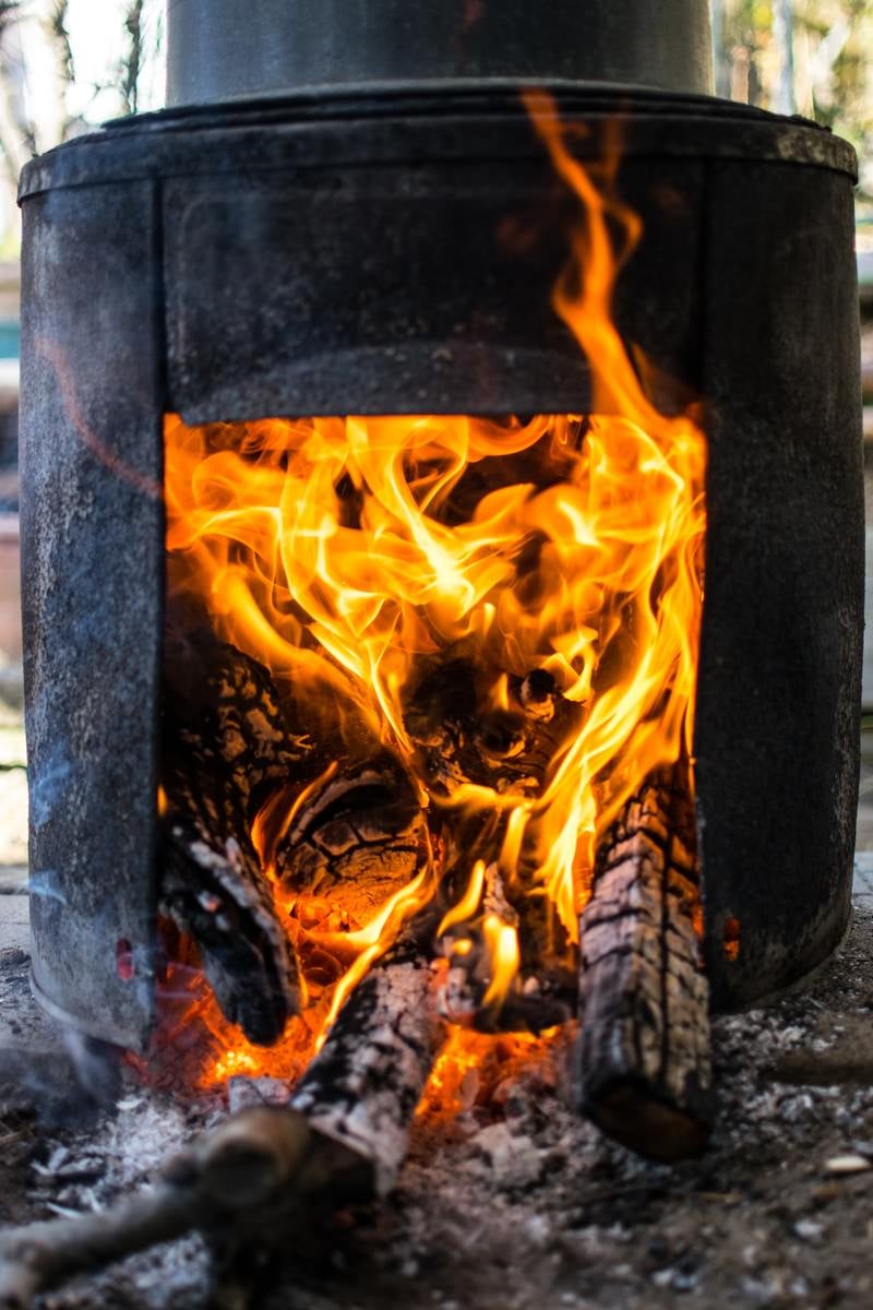 「釜戸で薪を燃やす」の写真