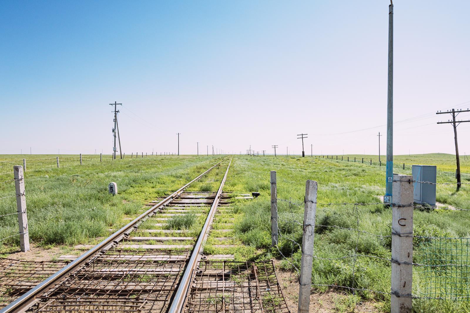 「草原の中、地平線まで伸びる線路」の写真