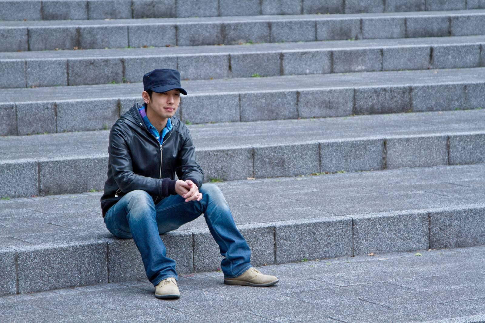 「階段に座り込む男性」の写真［モデル：大川竜弥］