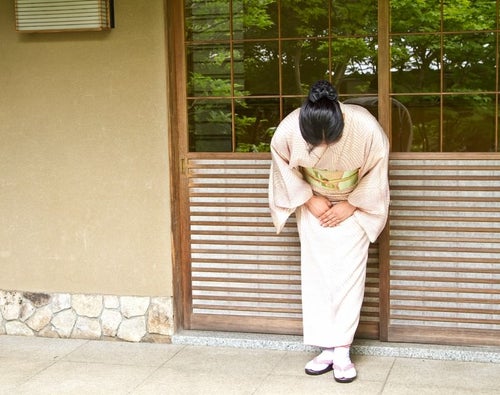 玄関先でお出迎えする女将さんの写真