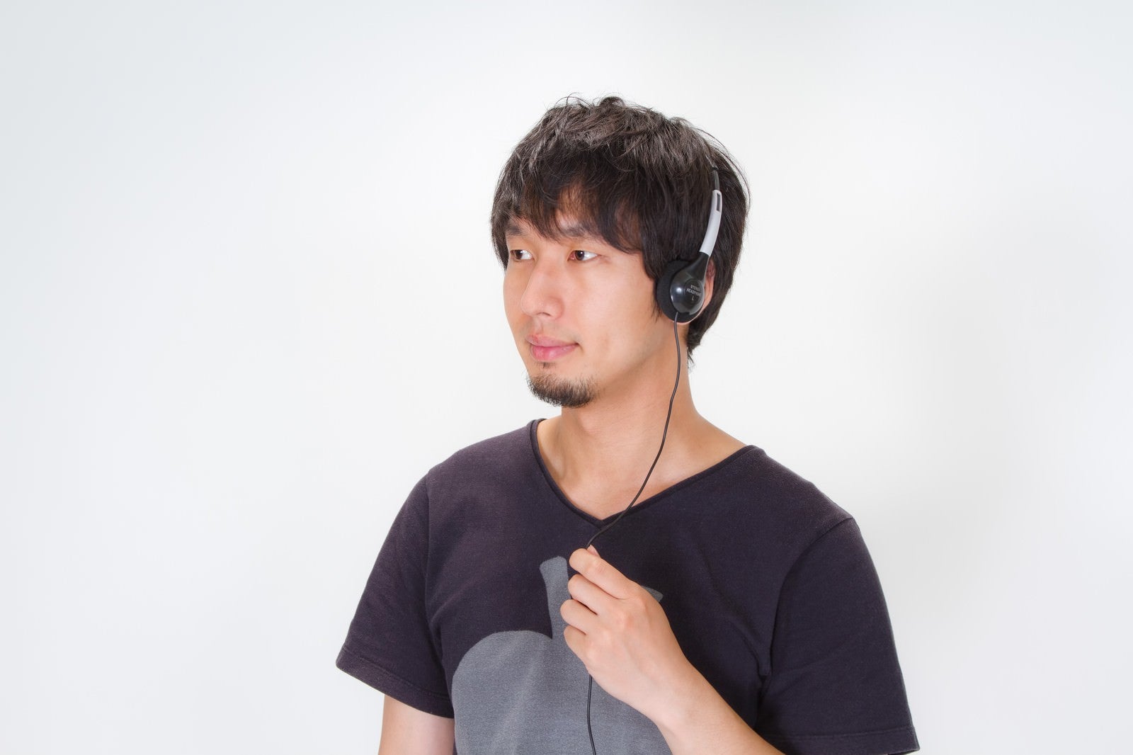 「ヘッドフォンで音楽を聴く男性」の写真［モデル：大川竜弥］