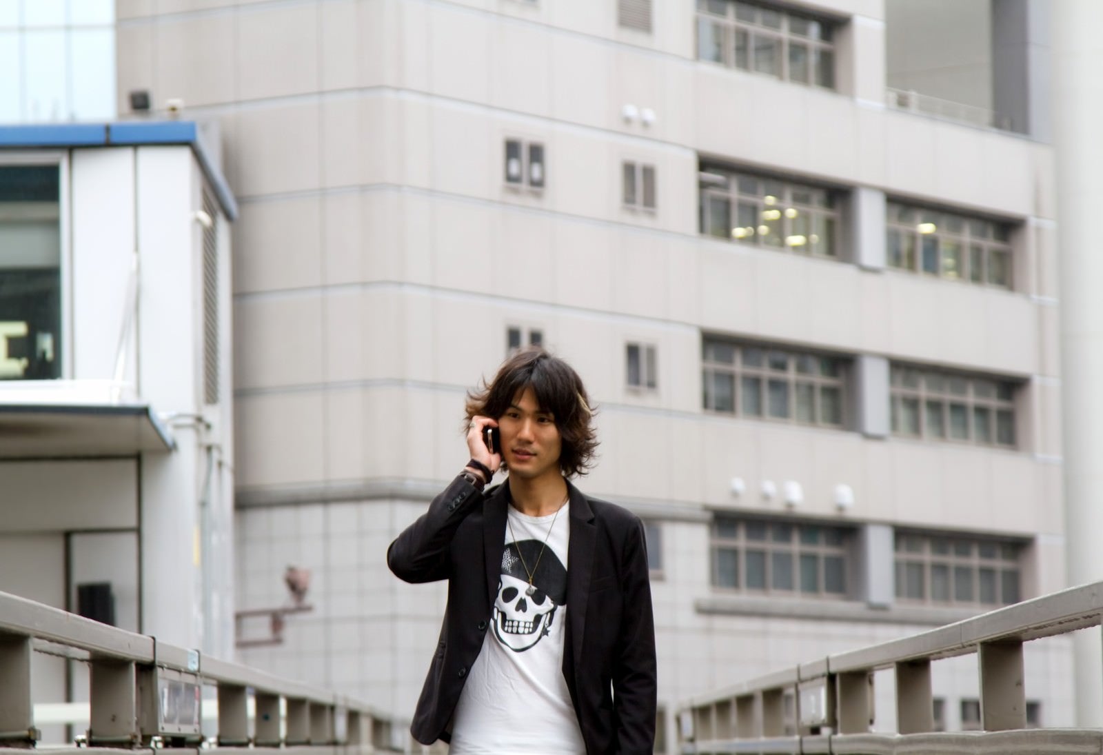 「歩道橋で電話する男性」の写真［モデル：村田裕章］