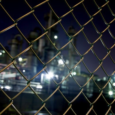 金網越しの工場（夜景）の写真