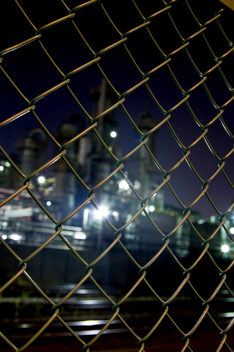 「金網越しの工場（夜景）」の写真