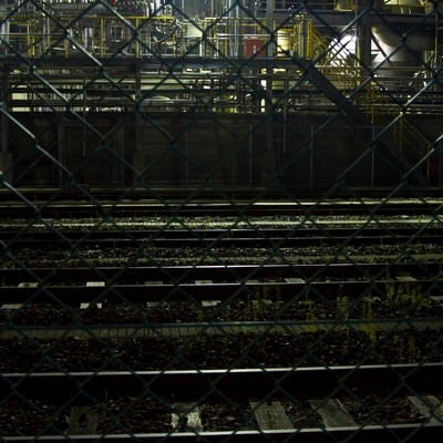 線路と夜の工場の写真