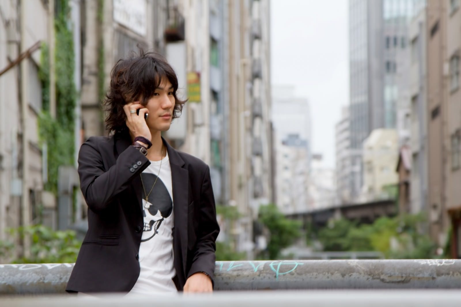 「渋谷川、橋の上で電話する男性」の写真［モデル：村田裕章］