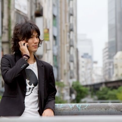 渋谷川、橋の上で電話する男性の写真