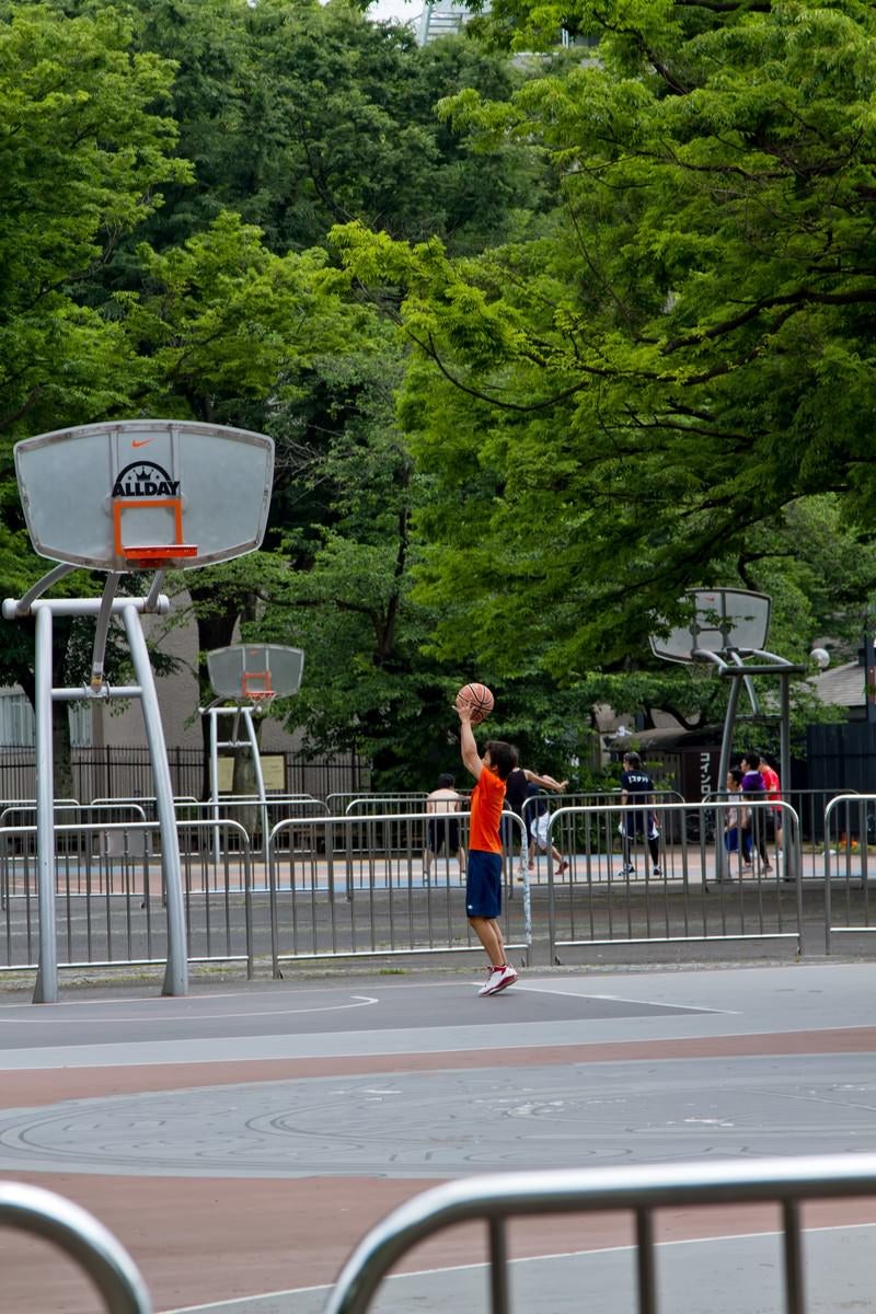 「代々木公園のバスケットコートで練習する少年」の写真