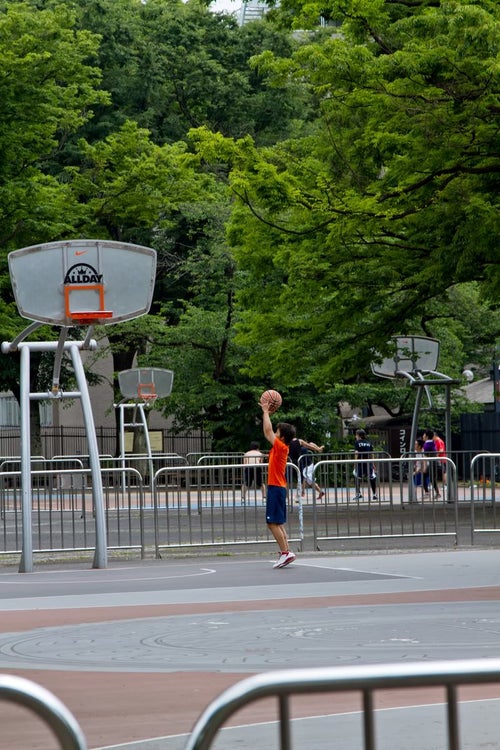 代々木公園のバスケットコートで練習する少年の写真