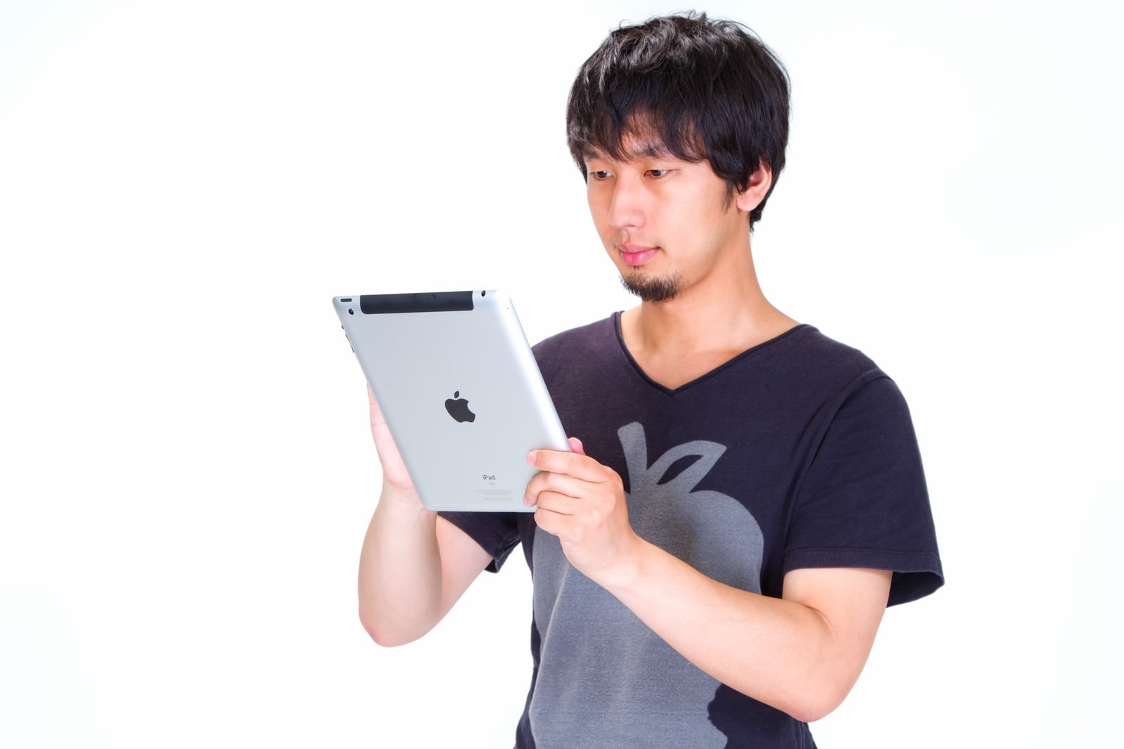 「iPad をいじる男性」の写真［モデル：大川竜弥］