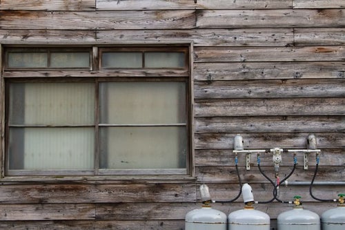 古い板張りの民家と窓の写真