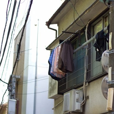 洗濯物が干された下町のアパートの写真