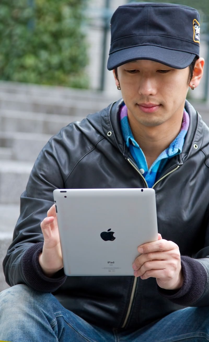「iPadを触る男性」の写真［モデル：大川竜弥］