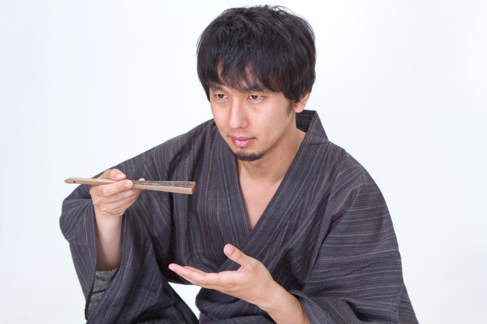 「扇子を使って何かを食べる浴衣男子」の写真［モデル：大川竜弥］