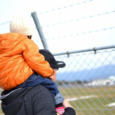 フェンスと肩車をした親子の写真