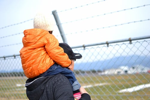 フェンスと肩車をした親子の写真