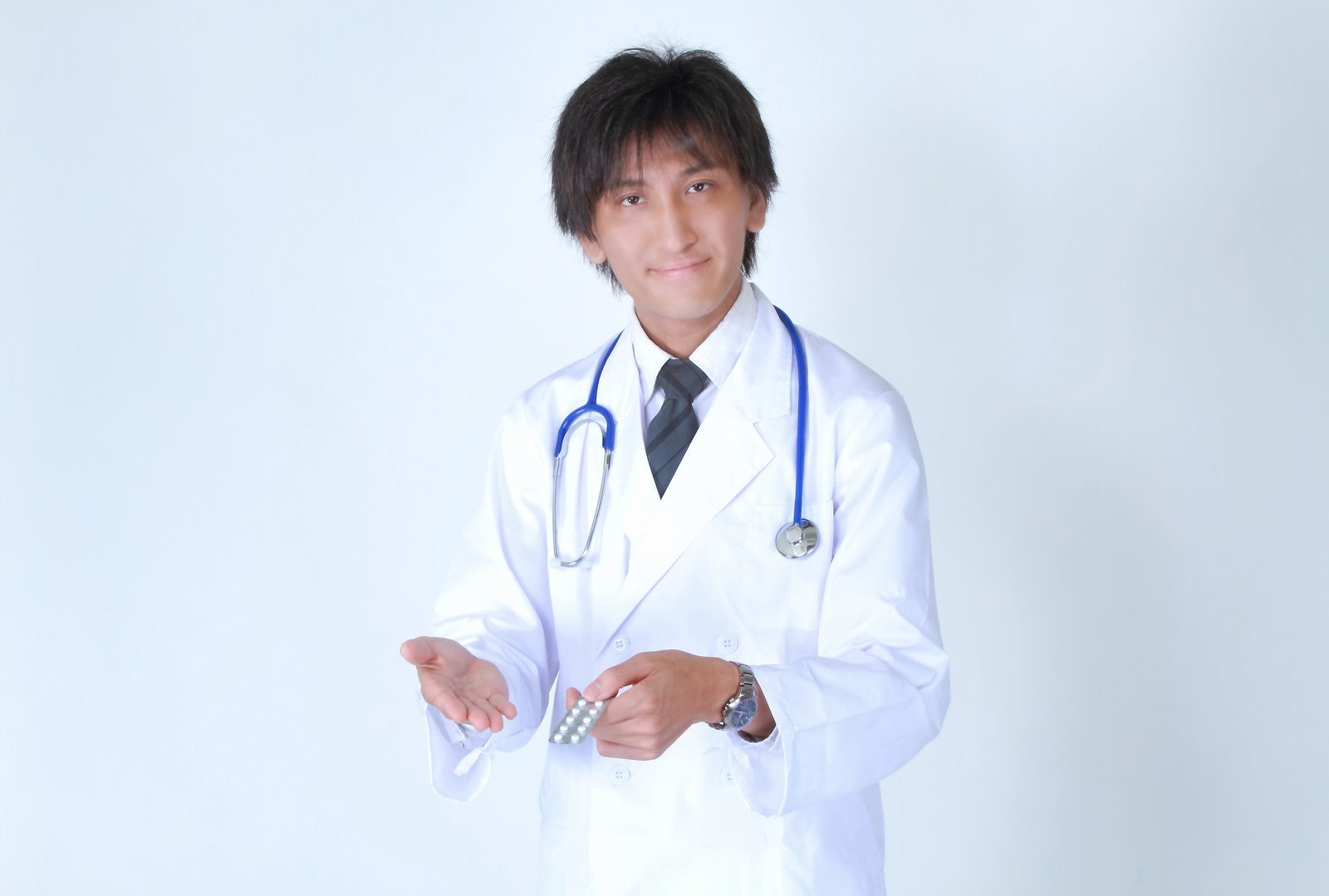 「お薬を提案する白衣を着たドクター」の写真［モデル：ACE］