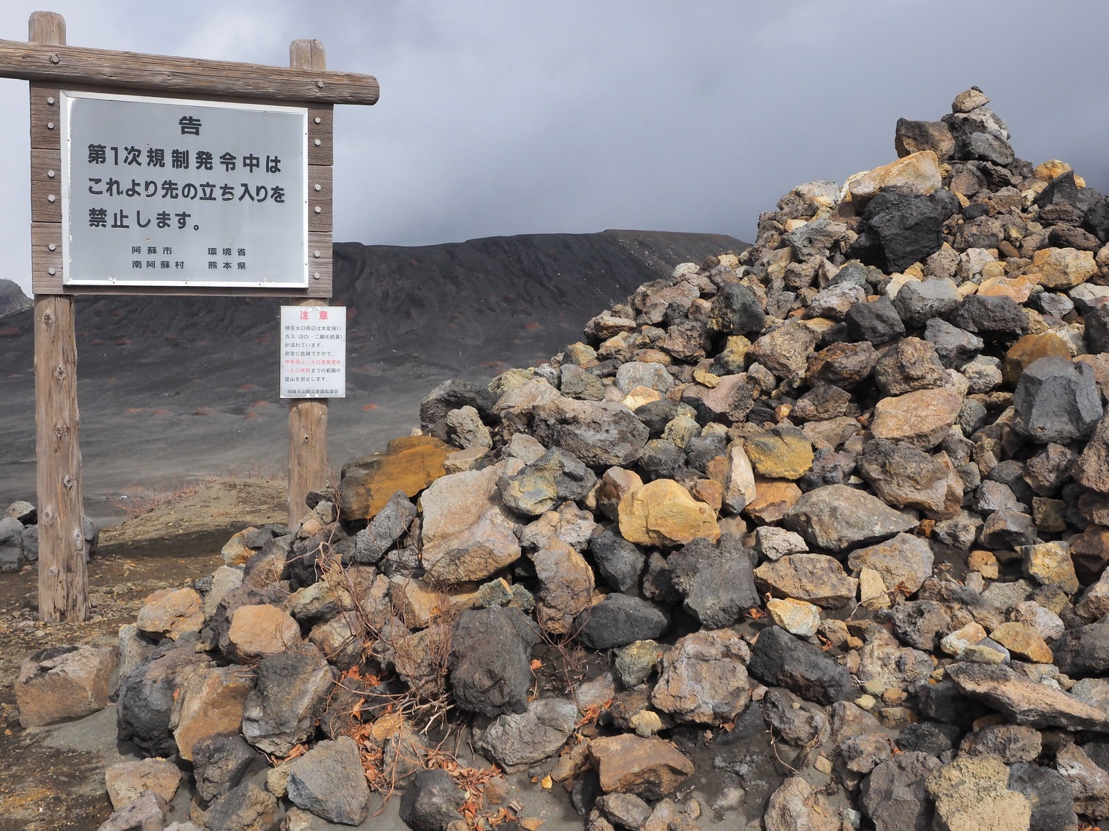 「阿蘇山の積まれた岩石と立ち入り禁止の看板」の写真