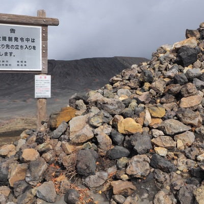 阿蘇山の積まれた岩石と立ち入り禁止の看板の写真