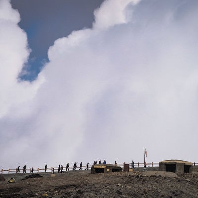 阿蘇火口を目指す登山者と雲の写真