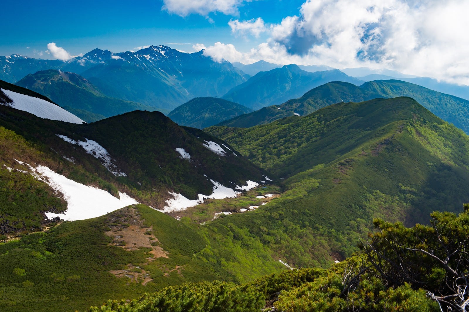 「雪が残る山間、乗鞍新登山道から見える景観」の写真