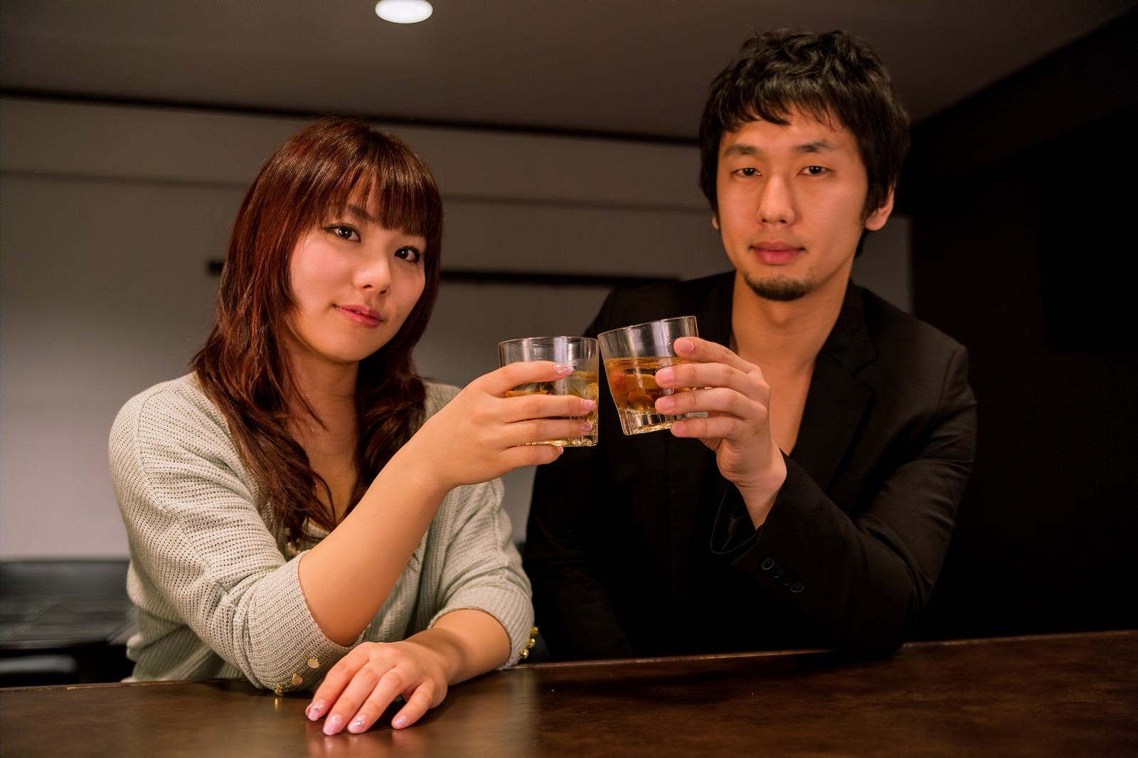「バーカウンターで乾杯する恋人」の写真［モデル：大川竜弥 Lala］