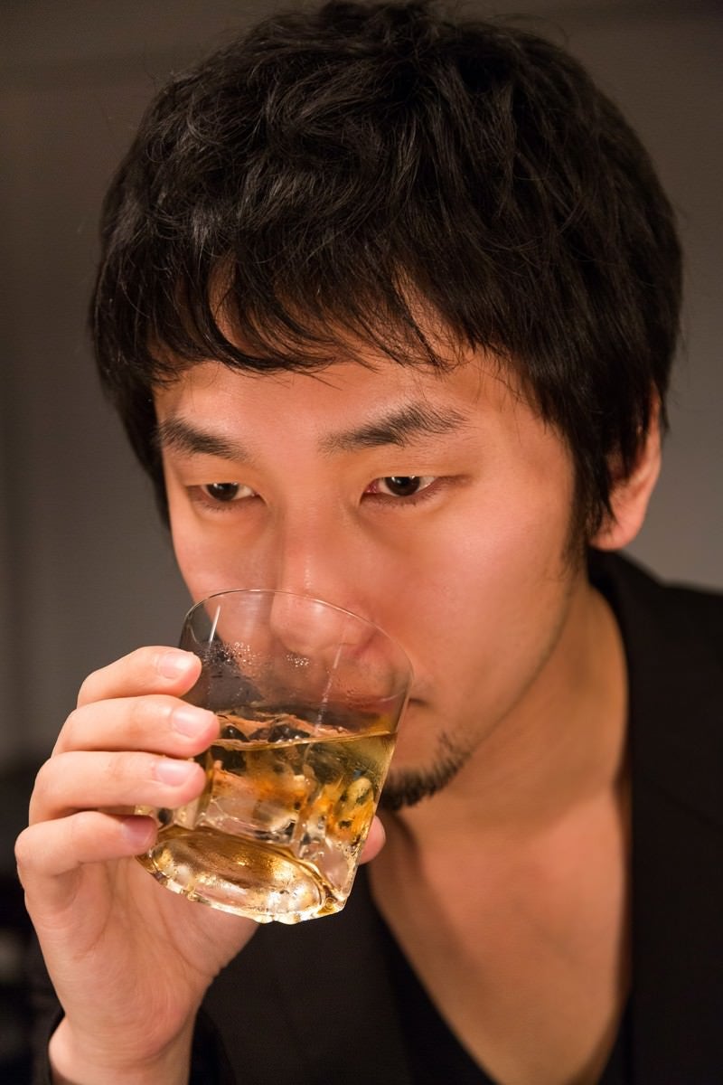 「「マイルドな口当たり」とウイスキーを飲む男性」の写真［モデル：大川竜弥］