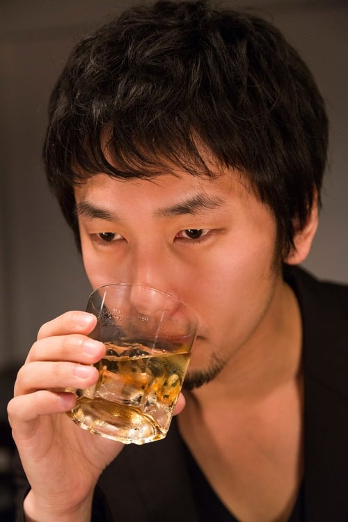 「マイルドな口当たり」とウイスキーを飲む男性の写真