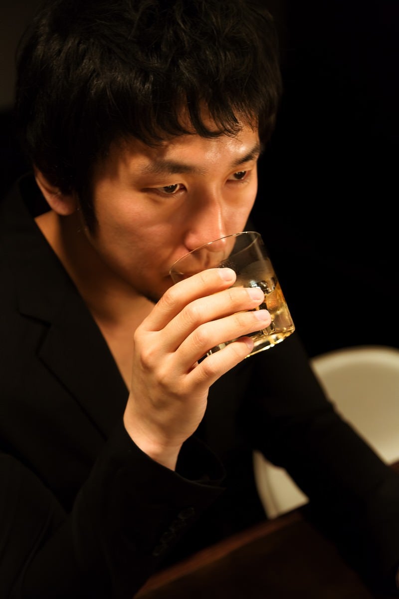 「ウイスキーを口にする男性」の写真［モデル：大川竜弥］