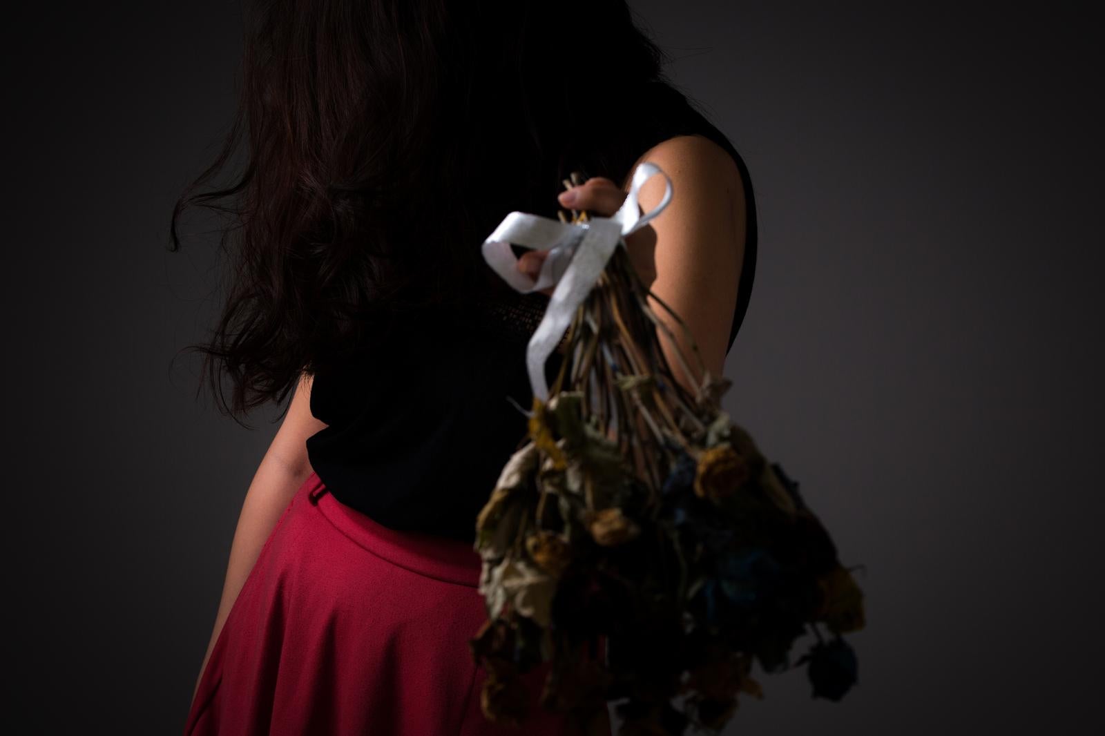 Eagle perched on the shoulder of a woman facing away