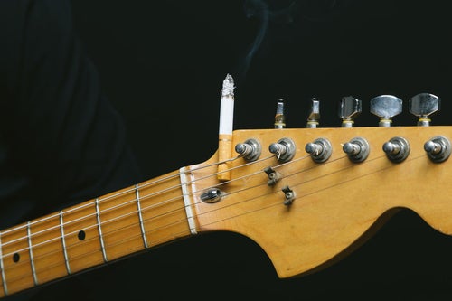 ギターのヘッドにタバコを挟む（焦げあと注意）の写真