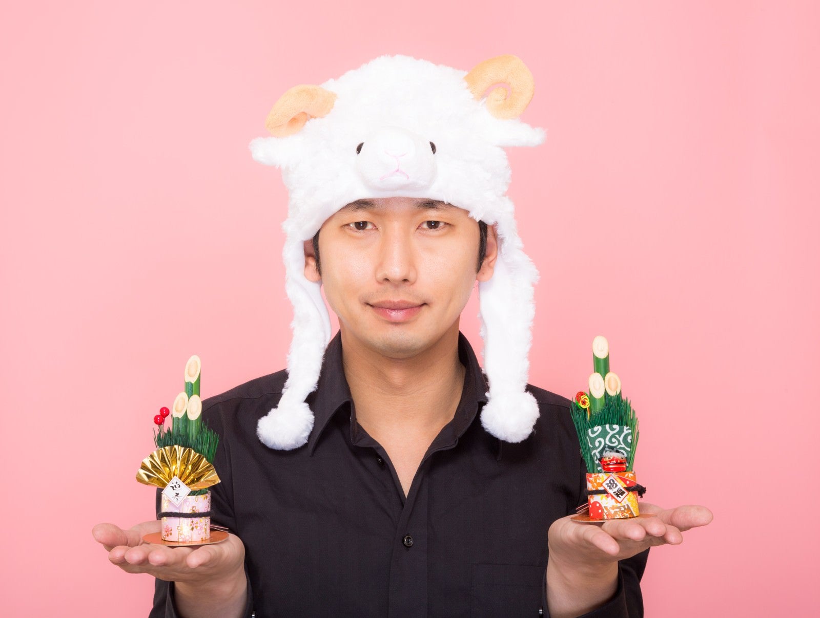 「新年！門松を両手に持った羊帽をかぶった男性」の写真［モデル：大川竜弥］