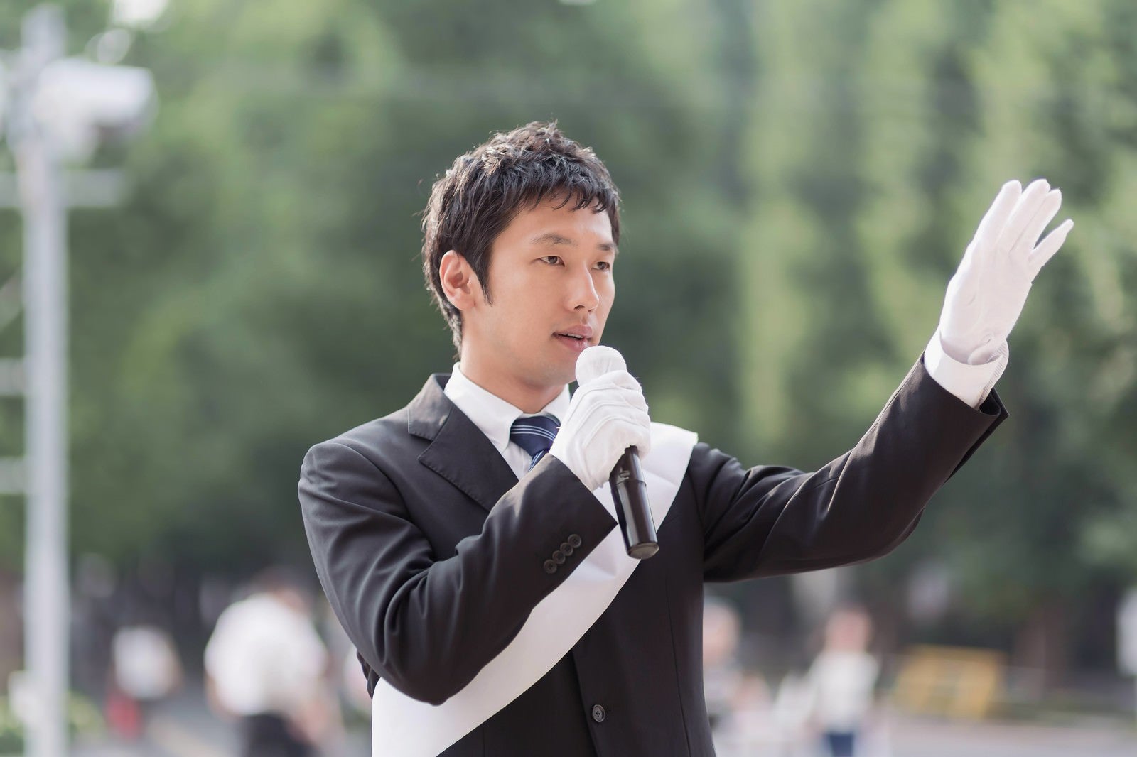 「タスキをかけて街頭演説をする男性」の写真［モデル：大川竜弥］