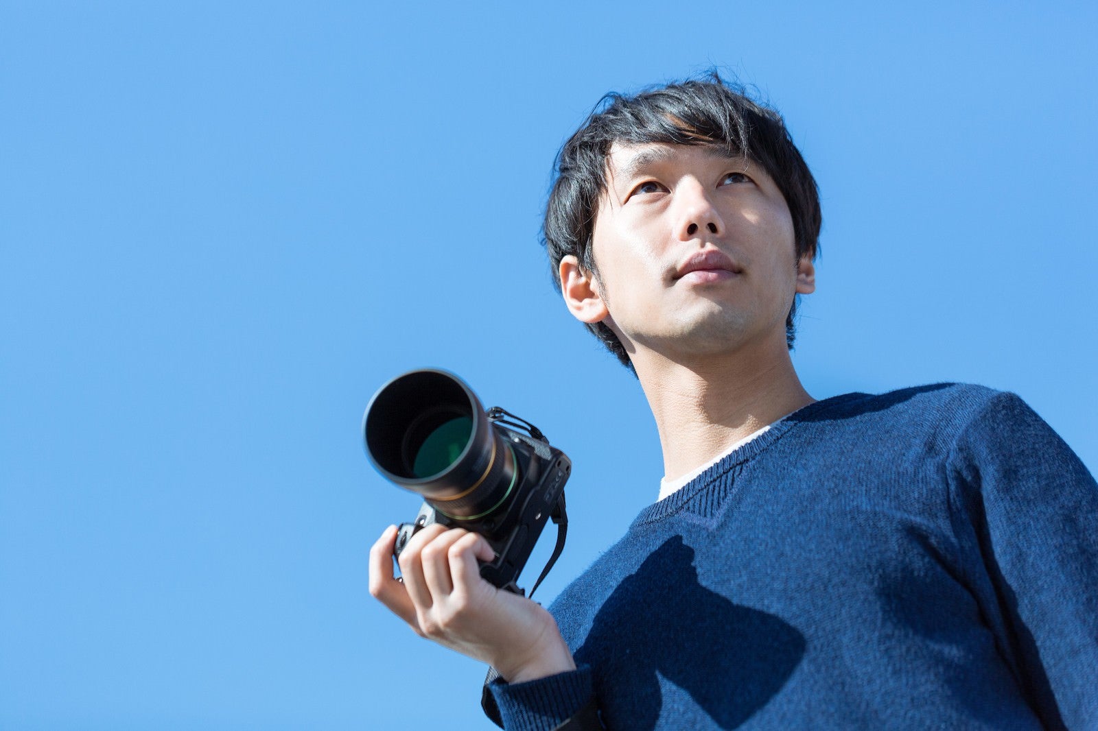 「お気に入りのカメラで外に出かけるカメラ男子」の写真［モデル：大川竜弥］