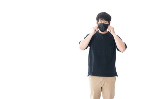 黒いマスクで顔を覆う男性の写真