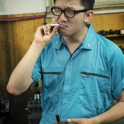 工場で煙草を吸う男性の写真