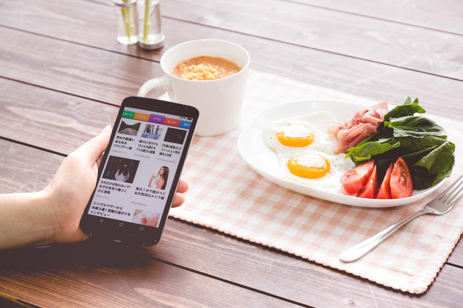 「朝食を食べながらニュースアプリをチェック」の写真