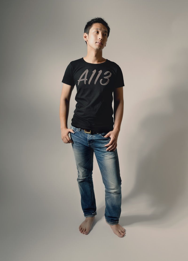 「A113と書かれたTシャツを着てポージングする男性」の写真［モデル：大川竜弥］