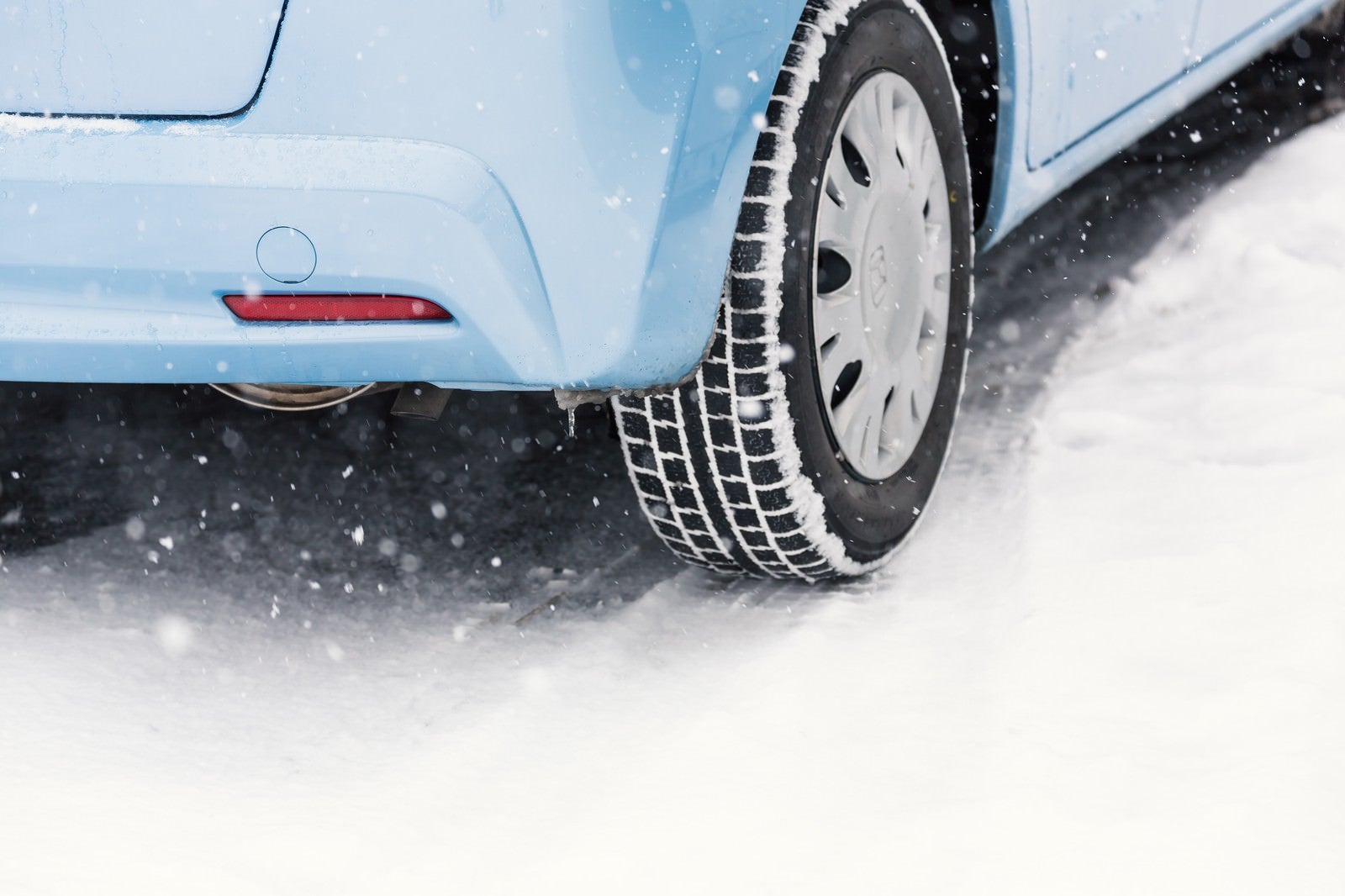 「雪道と車のスタッドレスタイヤ」の写真