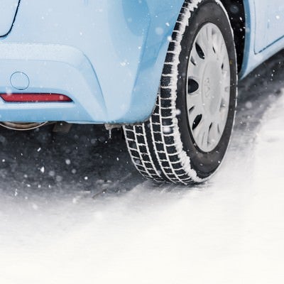 雪道と車のスタッドレスタイヤの写真