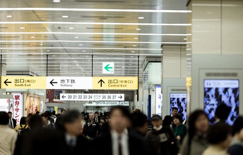 新幹線乗り場の人混みと案内板の写真