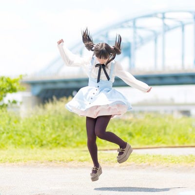 橋を背景に元気よくジャンプするツインテール姿の魔法少女の写真