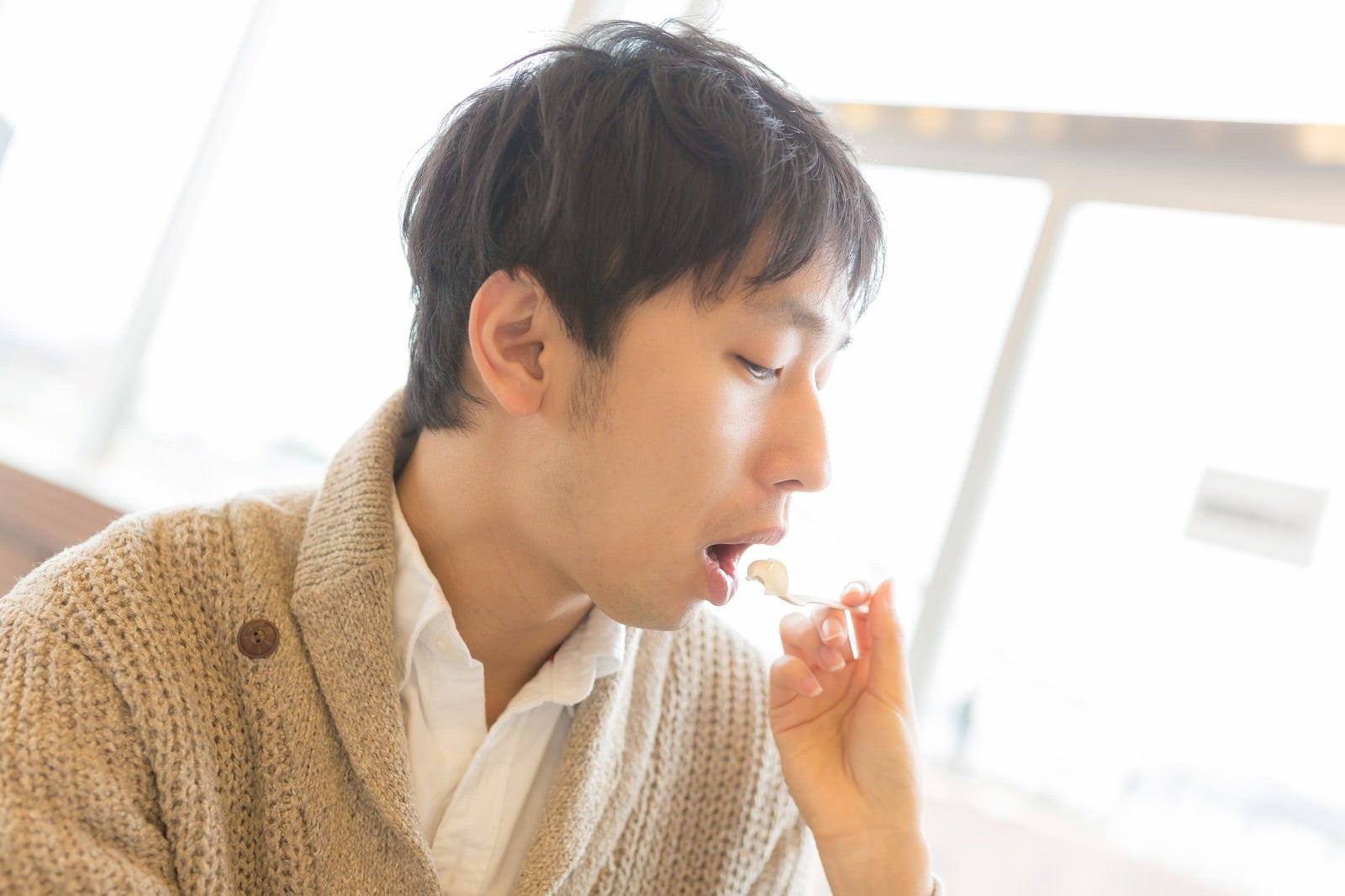 「カフェでアイスを「あーん」する男性」の写真［モデル：大川竜弥］