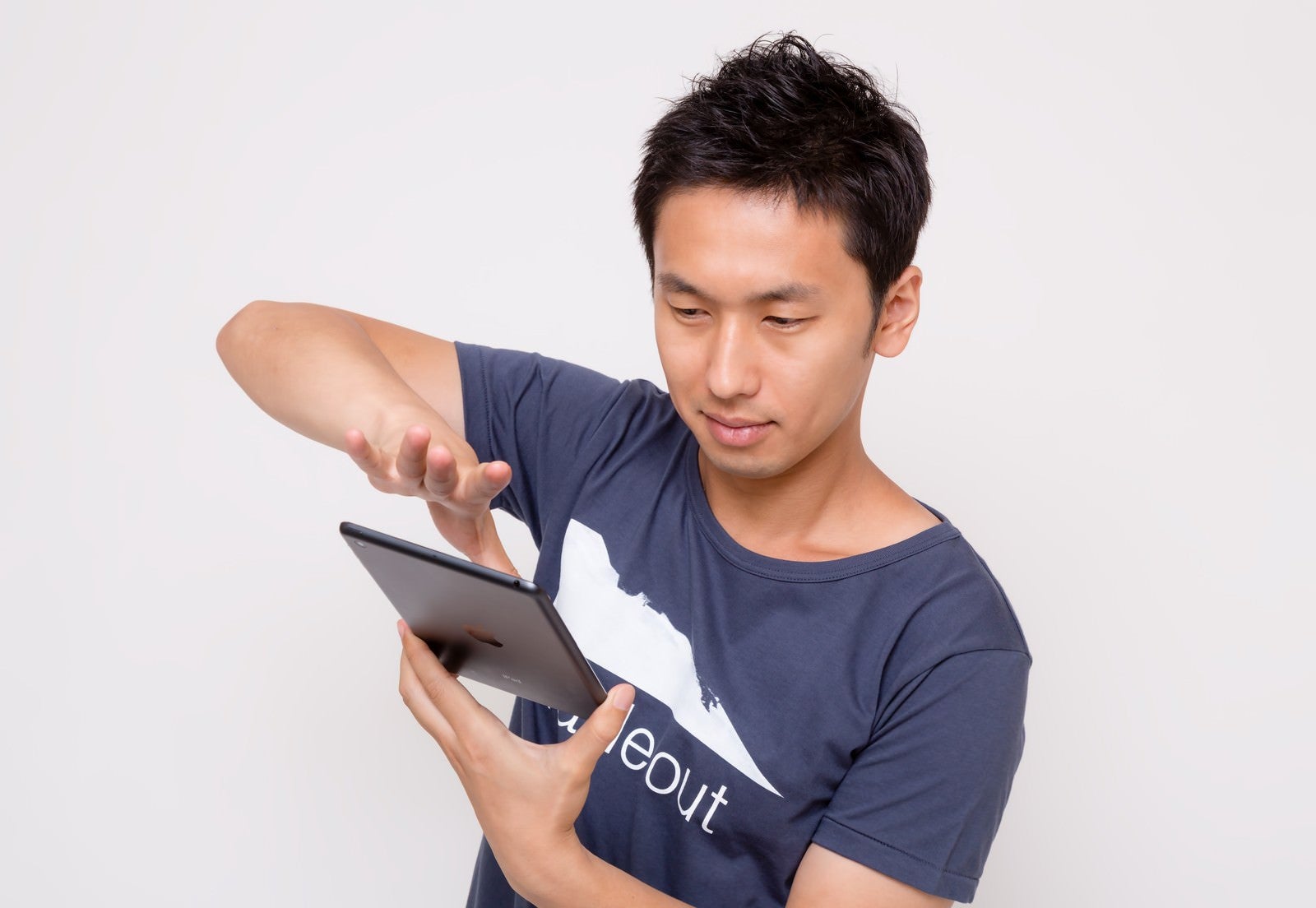 「iPad miniでスワイプする男性」の写真［モデル：大川竜弥］