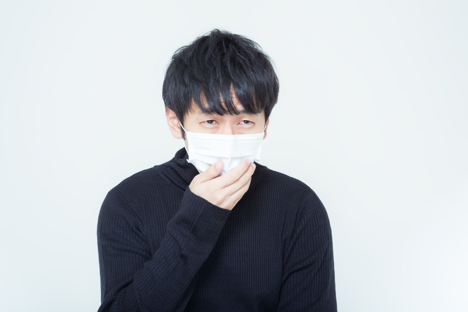 「花粉症に悩まされるマスクを付けた男性」の写真［モデル：大川竜弥］